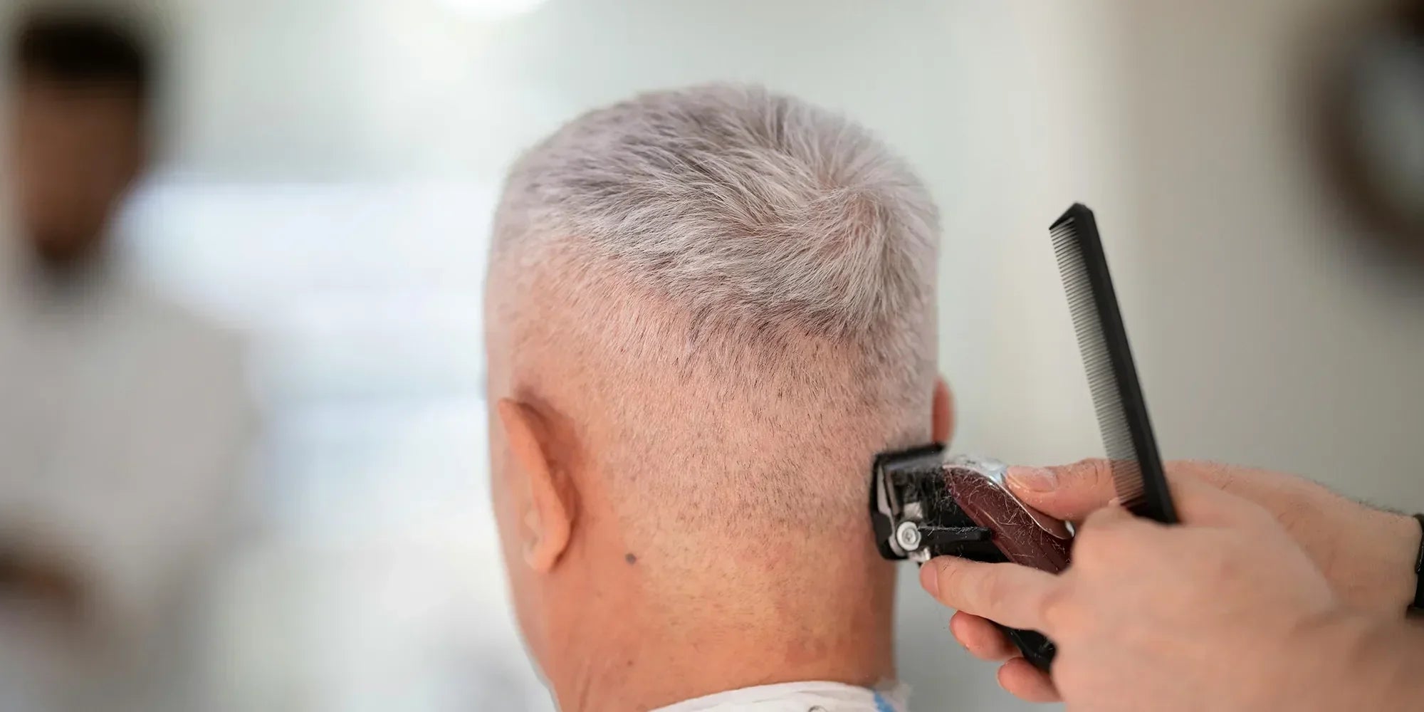 Mann beim Einschnitt eines Haarsystems