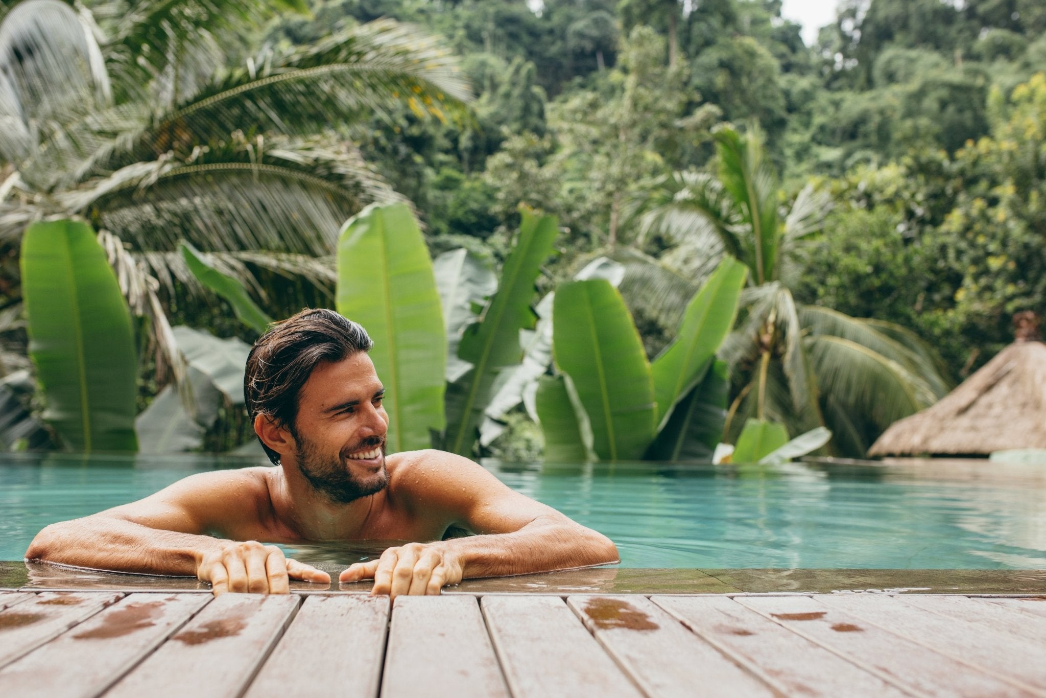 junger Mann mit Haarsystem im Pool