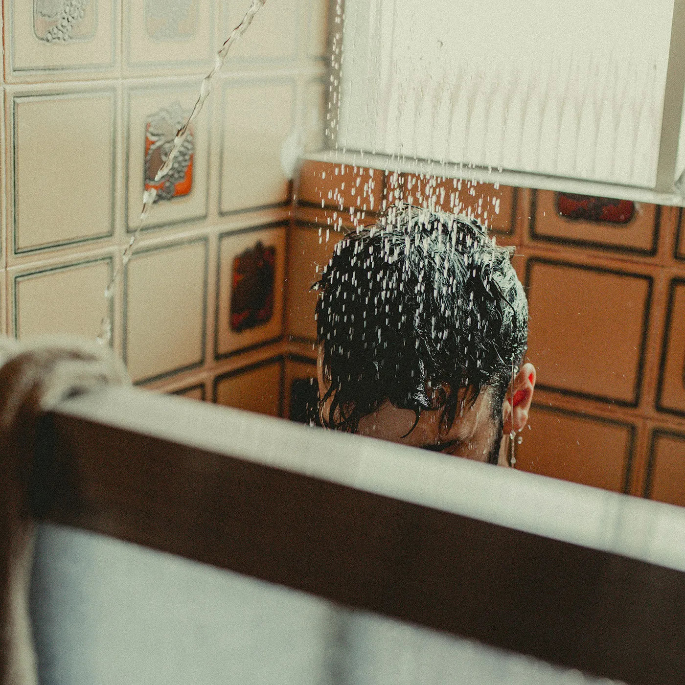 mann unter dusche mit haarsystem